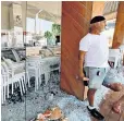  ??  ?? A man stands outside Henry Sasin’s damaged Victory ice cream parlour