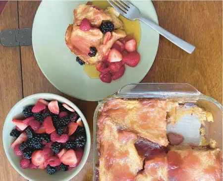  ?? JEANMARIE BROWNSON/TNS ?? Berries sprinkled between the layers adds great flavor and texture to this French toast dish.