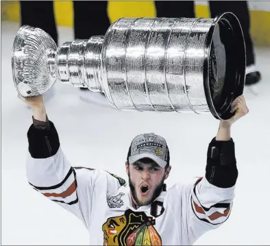  ?? CHARLES KRUPA/ THE ASSOCIATED PRESS ?? Blackhawks right wing Patrick Kane hoists the Stanley Cup after Chicago’s 3-2 victory over the Bruins in Game 6 on Monday night at Boston. Kane won the Conn Smythe Trophy as the postseason Most Valuable Player, compiling nine goals and 10 assists.