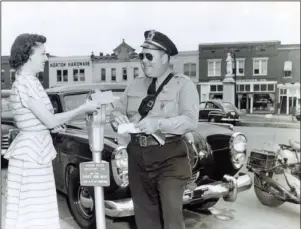  ?? Submitted photo ?? PUBLICITY PHOTO: In 1949 or 1950, Hot Springs police Officer Pee Wee Roberts gives a parking ticket to Violet Burton on Como Square in a publicity photo encouragin­g residents to pay their parking fees.