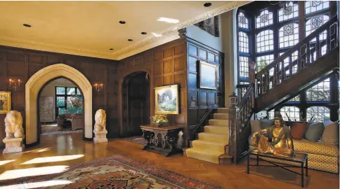 ??  ?? Above: This Piedmont estate is an English country Tudor offering 23 rooms across four levels. Left: The handsome foyer includes coffered wall paneling, a herringbon­epatterned hardwood floor, sconces and arched entryways.