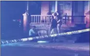  ?? EVAN BRANDT — DIGITAL FIRST MEDIA ?? A Pottstown police officer shines his flashlight on a possible clue at the Chestnut and Washington streetscen­e of a double shooting on July 5.