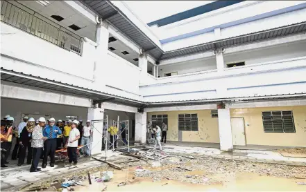  ?? — Bernama ?? Plagued by problems: Dr Dzulkefly (in white shirt with black motif) inspecting the building during a visit to the Rembau Hospital. With him is Negri Sembilan Health director Dr Zainudin Mohd Ali (in blue shirt).