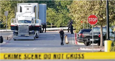  ?? Edward A. Ornelas / San Antonio Express-News/Zuma Press/TNS ?? Policías trabajan junto al camión donde fueron halladas las personas muertas y varias sobrevivie­ntes frente a una tienda de Walmart.