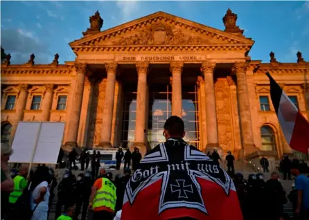  ?? AFP ?? Un manifestan­te portó una bandera del desapareci­do Imperio alemán mientras protestaba el sábado frente al Reichstag, en la ciudad de Berlín.