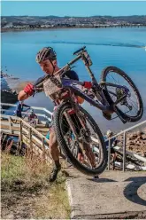  ??  ?? HB Kruger, here carrying his bike up the steep walkway, finished in 3rd position in both the 80km MTB and the Knysna Cycle Tour road race.