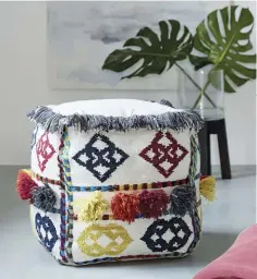  ??  ?? Versatilit­y is key with this cube that can function as a footstool, a seat or even a tabletop. Moroccan pom-pom pouf, $149. Visit westelm.com.