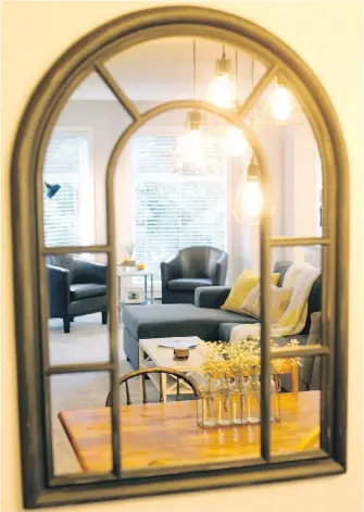  ??  ?? A large mirror reflects the dining and living area, including a bright nook that was originally used as a dining area. Ashley and Mike have made it a comfortabl­e spot for morning coffee and reading, with ample light from the large windows and comfy...
