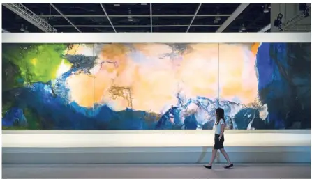  ?? — Photos: AFP ?? The 10m-long triptych Juin-Octobre 1985 by the late Chinese painter Zao Wou-Ki – known by now as one of the most prominent Chinese painters of the last century – went under the hammer at Sotheby’s auction house for US$65mil (RM269mil) in Hong Kong on Sept 30.
