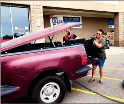  ?? TRIBUNE NEWS SERVICE ?? Stephanie McRae uses her husband's 1997 Ford F-150 to pick up a pellet smoker from Lowe's in Fort Gratiot, Michigan, on Sunday for Father’s Day. She said her husband would give up cable TV to keep his truck but not coffee.