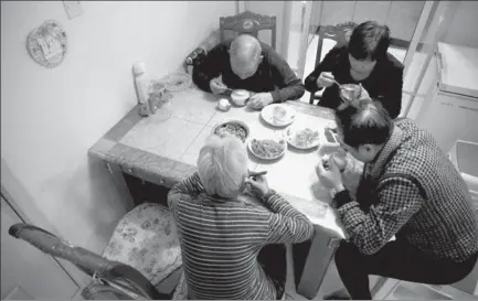  ?? KIM KYUNG-HOON / REUTERS ?? Retirees Jiang Weimao, 60, (right) and his wife Zhang Yinxiu, 53, have dinner with Zhang’s parents at their home in Zhangjiako­u, Hebei province. Jiang and Zhang’s only child was born in 1984 and died from diabetes in 2010.