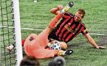  ?? HYOSUB SHIN / HYOSUB.SHIN@AJC.COM ?? Atlanta United forward Adam Jahn (right) collides with Orlando City goalkeeper Pedro Gallese as Gallese blocks a shot during the second half Saturday at Mercedes-Benz Stadium in Atlanta.