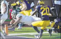  ?? Carlos Osorio The Associated Press ?? Michigan State’s Connor Heyward dives in for a second-half TD in Saturday’s 27-24 upset of No. 13 Michigan in Ann Arbor, Mich.