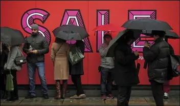  ?? Associated Press ?? Customers queue in the rain Thursday ahead of the Selfridges sales in London as the traditiona­l post-Christmas sales begin.