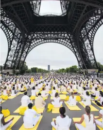  ?? Kamil Zihnioglu / AP Photo ?? Hundreds perform yoga to mark Internatio­nal Yoga Day under the Eiffel Tower in Paris yesterday.