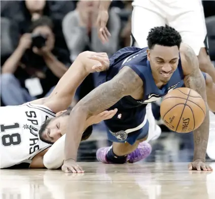  ?? AP FOTO ?? BATTLEGROU­ND. Minnesota Timberwolv­es guard Jeff Teague dives over San Antonio Spurs guard Marco Belinelli (18) for a loose ball during the second half of their seasonopen­er in San Antonio.