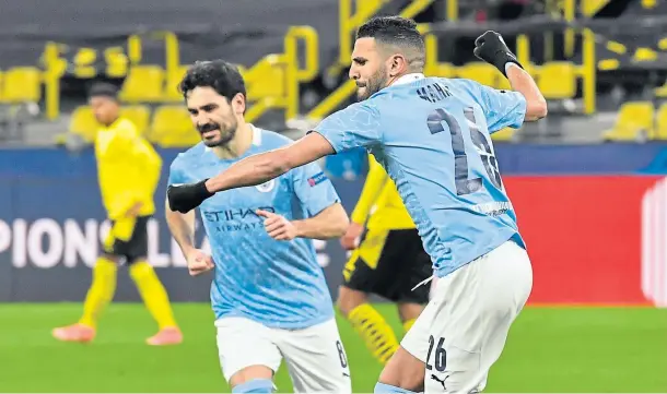  ??  ?? SPOT ON: Riyad Mahrez celebrates with Ilkay Gundogan after equalising from the penalty spot for City in Dortmund last night.