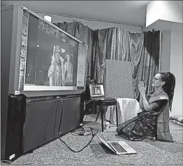  ??  ?? Members of the Nithyanand­eshwara Hindu Temple sometimes listen to a video feed from India, as Ma Bodhanna Kothari does at the Delaware facility.