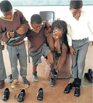  ?? Picture:SUPPLIED ?? BE THE CHANGE: TeeLo Foundation founder Tabisa Loliwe assists needy children from Tsholomnqa with school uniforms, shoes and their homework