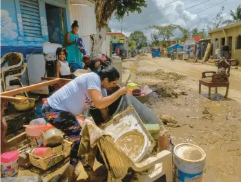  ?? RICARDO HERNANDEZ/AP ?? Residents work to recover and clean belongings Tuesday after flooding in Higuey, Dominican Republic.