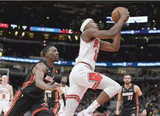  ?? AP ?? Ayo Dosunmu goes up for a shot Saturday against the Heat. Bulls coach Billy Donovan said Dosunmu has been strong on defense but is trying to figure some things out on offense.