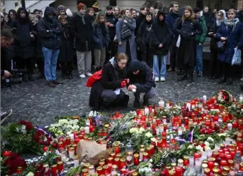  ?? Petr David Josek/Associated Press photos ?? Mourners lay candle lights Friday outside the headquarte­rs of Charles University for victims of a mass shooting in Prague, Czech Republic. A lone gunman opened fire at a university on Thursday, killing 14 and injuring scores of people.