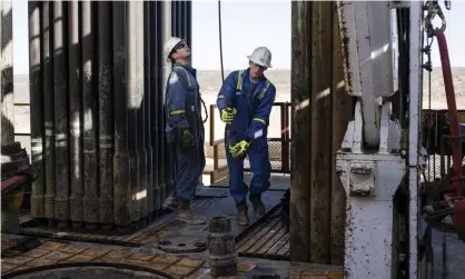  ??  ?? Royal Dutch Shell rig operators in Texas. Oil and gas companies have been told they could be downgraded between one and two notches as S&P increases risk rating for the entire sector. Photograph: Bloomberg/Getty Images
