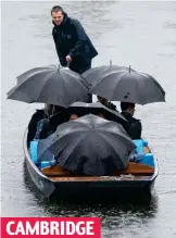  ?? ?? CAMBRIDGE
Pour guide: Punters resort to brollies