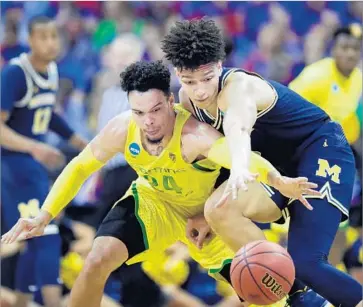  ?? Jamie Squire Getty Images ?? DILLON BROOKS, left, of Oregon goes all out in pursuit of the ball, as does Michigan’s D.J. Wilson.