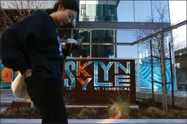  ?? ARIC CRABB —BAY AREA NEWS GROUP ?? Gwen Wang walks past the Skylyne at Temescal apartment building in Oakland. When she signed papers to live there in August, Wang's 14-month lease included two months of free rent, she said.