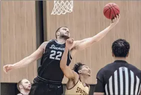  ?? Robert Simmons / ACC ?? Daemen senior center Andrew Sischo (22), a Guilderlan­d native, reaches to corral a rebound away from a St. Thomas Aquinas forward on Tuesday.