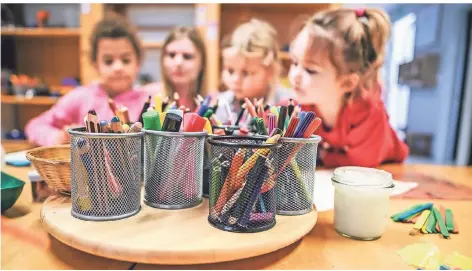  ?? FOTO: LARS FRÖHLICH ?? Die Kinder Lauren, Evelina und Melina (v. l.) malen mit Erzieherin Tanja Tibo an einem Tisch in der Notbetreuu­ng der Kita Schepersfe­ld.