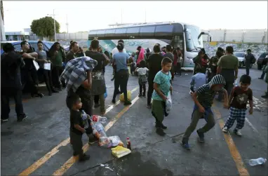  ?? MARCO UGARTE — THE ASSOCIATED PRESS ?? In this July 16, 2019 photo, migrants wait outside at an immigratio­n center on the Internatio­nal Bridge 1, to be bused from Nuevo Laredo to Monterrey Mexico. The migrants went willingly knowing the dangers that lurk in Tamaulipas, where organized crime groups have been known to extort, kidnap and kill people like them.