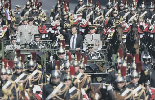  ??  ?? French President Emmanuel Macron, left, and his Chief of the Defence Staff Gen. Pierre de Villiers, right, drive down the Champs Elysees.