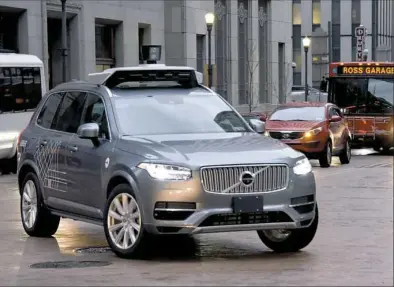  ?? Darrell Sapp/Post-Gazette ?? An Uber autonomous Volvo turns onto Seventh Avenue from Grant Street during the morning rush.