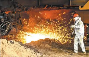  ?? ZHAO GE / XINHUA ?? A worker stands beside a blast furnace at a steel plant in the Xinjiang Uygur autonomous region.