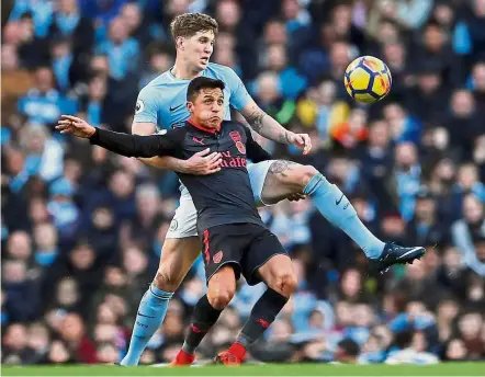  ??  ?? Big hurdle: Arsenal’s Alexis Sanchez trying to shield the ball from Manchester City’s John Stones at the Etihad on Sunday. — Reuters