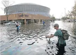  ??  ?? A man pushes his bicycle through flood waters near the Superdome in New Orleans on Aug. 31, 2005, after Hurricane Katrina left much of the city under water.