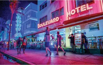  ?? — AFP photos ?? Revelers walk on a nearly empty Ocean Drive in South Beach during this Spring Break weekend.