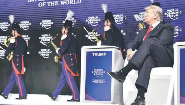  ??  ?? ► Donald Trump observa una banda antes de realizar su discurso en el Foro Económico Mundial de Davos, ayer.