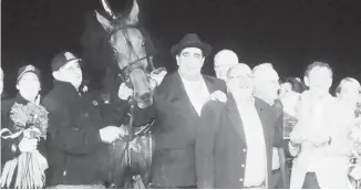  ??  ?? Owner Mel Hartman, front, accepts the winner’s plaque after Bee A Magician won the Breeders Crown final for three-year-old filly trotters on Saturday at Pocono Downs in Wilkes-Barre, Penn.