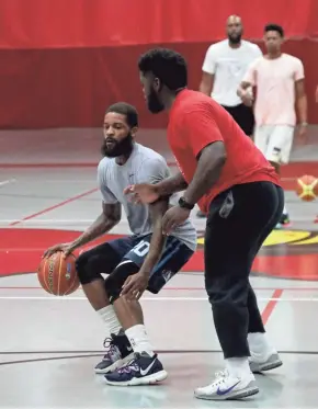  ?? SENTINEL LAYLA JOHNSON / MILWAUKEE JOURNAL ?? Basketball trainer Thomas Shumpert (front) works with Korie Lucious on his ball handling at Milwaukee South High School.