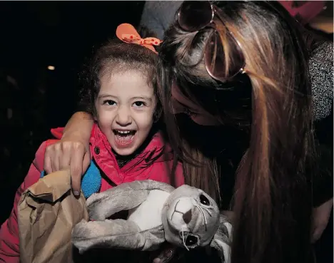  ?? LEAH HENNEL/CALGARY HERALD ?? Maysa Yousef, 3, is greeted at Calgary Internatio­nal Airport by family member Mishleen William. She’s among the first Syrian refugees to arrive.