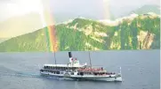  ?? AP PHOTOS ?? Left: A ferry on Lake Lucerne, Switzerlan­d, with a rainbow visible against the mountains. Right: Swans and the Chapel Bridge in Lucerne, which is listed as one of best 50 places in the world to travel in 2017.