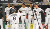  ?? WBC REPORT EUGENE HOSHIKO AP ?? Japan’s Kensuke Kondoh (8) celebrates with Shohei Ohtani of Japan after hitting a solo home run Friday.