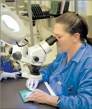  ?? NWA Democrat-Gazette/ANDY SHUPE ?? Teresa Edwards, a surface-mount solder inspector, looks at a circuit board meant for use in a parking meter on Tuesday while working at Keytronic EMS in Fayettevil­le.