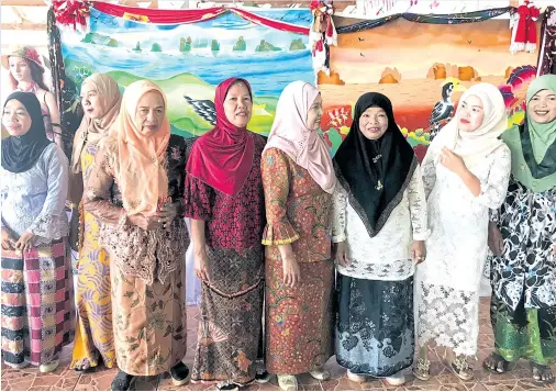  ??  ?? A group of Ban Tha Khao housewives introduce themselves to visitors before holding a batik workshop.