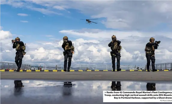  ?? PO Phot Si Ethell ?? Ranks from 42 Commando Royal Marine’s Fleet Contingenc­y Troop, conducting high vertical assault drills onto RFA Mounts Bay in Portland Harbour, supported by a Ghost drone