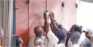  ?? Angry members of GUTA locking up a shop in Acrra- Source Myjoyonlin­e ??