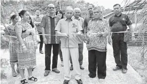  ??  ?? SELAMAT DATAI: Masir (tengah) benung ngempat riben seraya dikemata Tuai Rumah Udin (kanan) sereta bala ketuai komuniti enggau kaban JKKK ke bukai lebuhka datai ba rumah panjai nya.